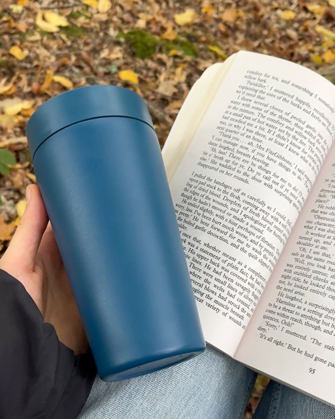 midnight blue stainless steel cup lifestyle shot with book