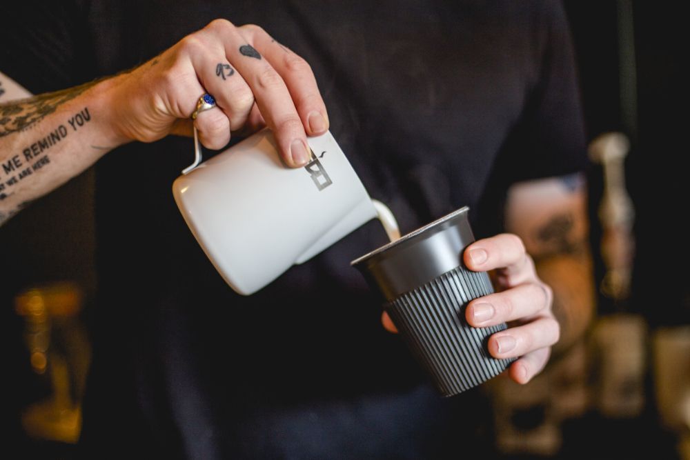 Man pouring milk into the Circular Returnable Cup.